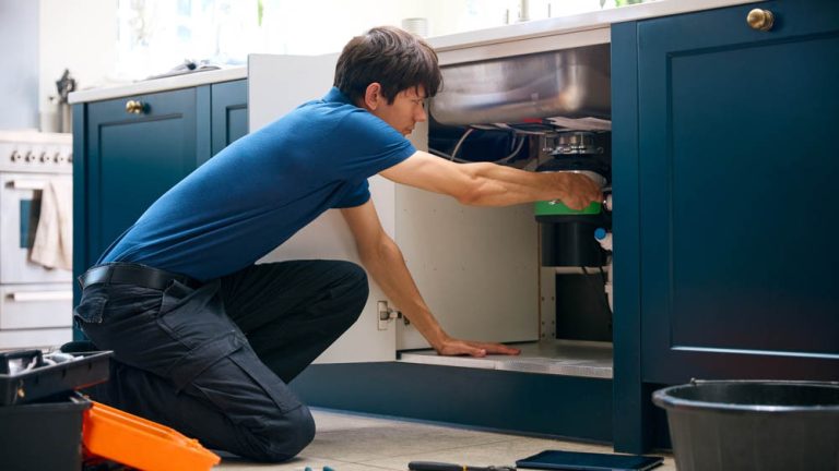 Sugar Bear technician installing a garbage disposal unit